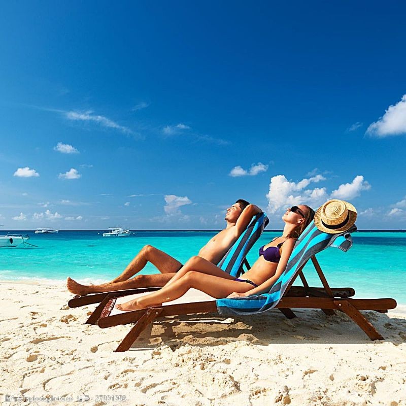 海滩上的美女享受阳光休闲椅上的情侣