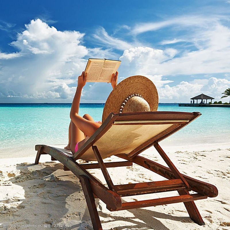 海滩上的美女躺在休闲椅上看书的美女