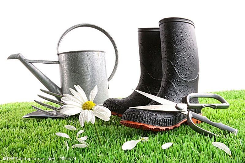美丽家园草地上的喷壶雨靴