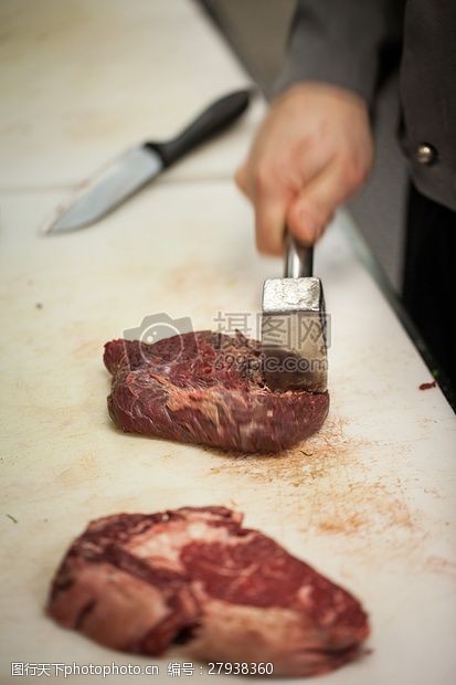 牛排锤正在切牛肉的手